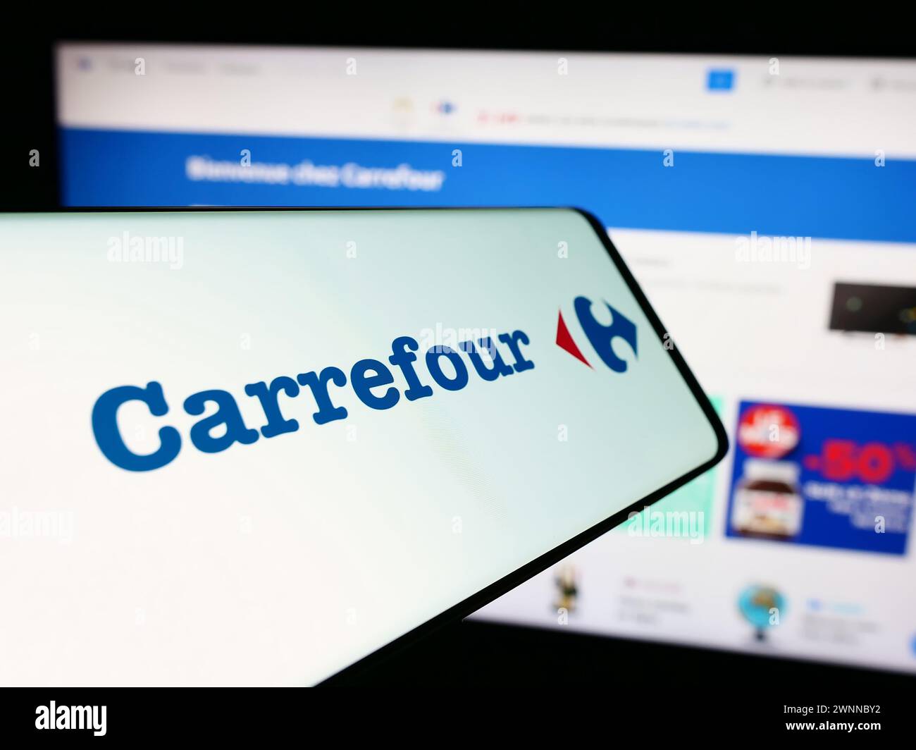 Smartphone con logo della società di vendita al dettaglio francese Carrefour S.A. davanti al sito Web aziendale. Mettere a fuoco la parte centrale destra del display del telefono. Foto Stock