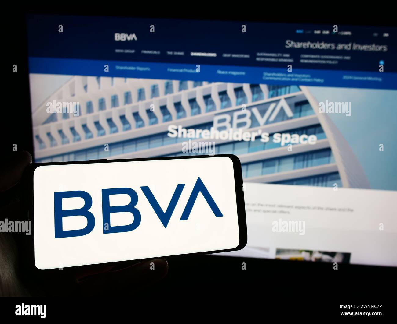 Persona che detiene lo smartphone con il logo della società Banco Bilbao Vizcaya Argentaria SA (BBVA) davanti al sito web. Mettere a fuoco il display del telefono. Foto Stock