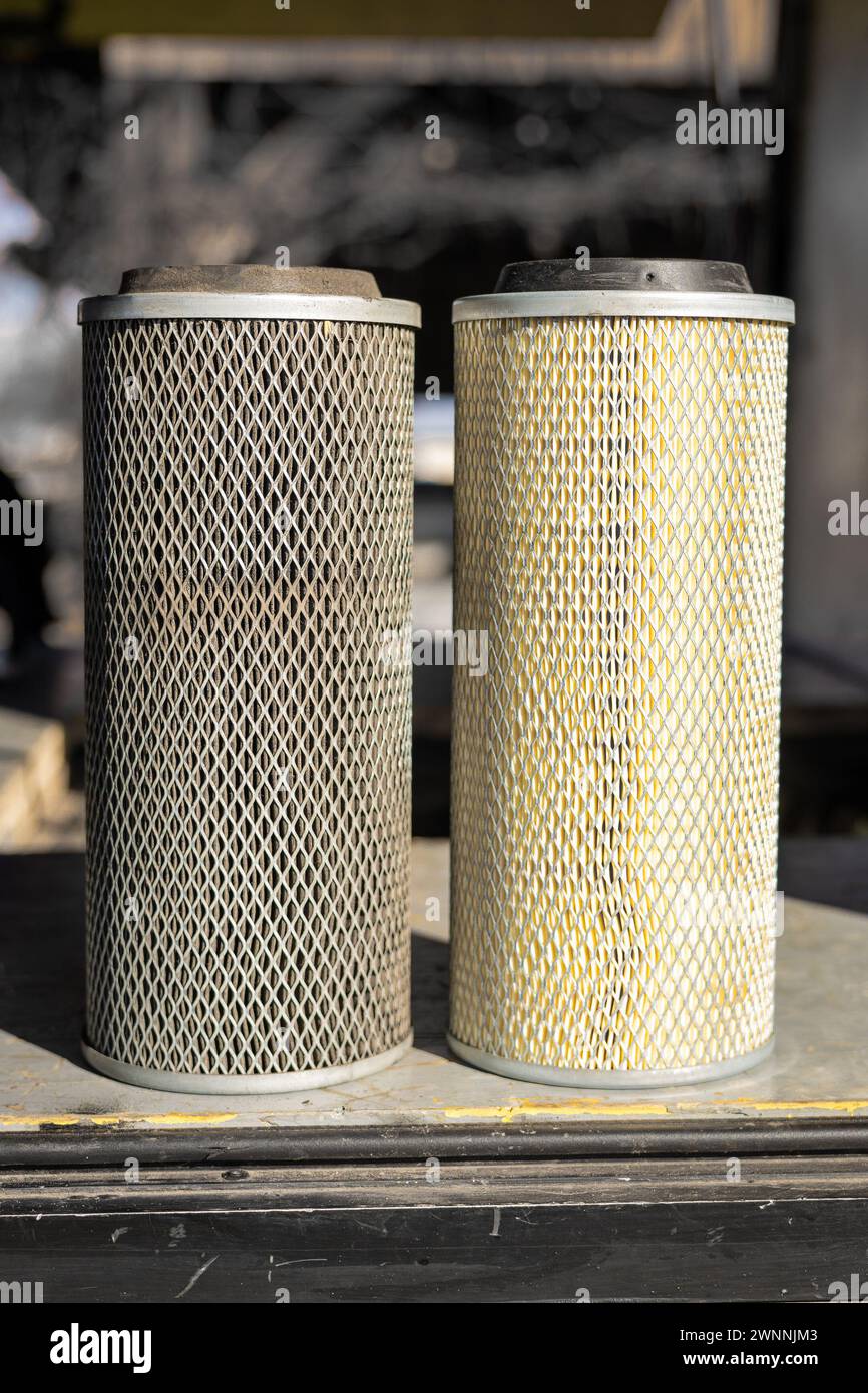 Confronto tra filtro dell'aria vecchio e nuovo di un veicolo industriale o furgone. Filtro a rete metallica con inserto di carta, lato a lato, versione sporca e pulita. Foto Stock