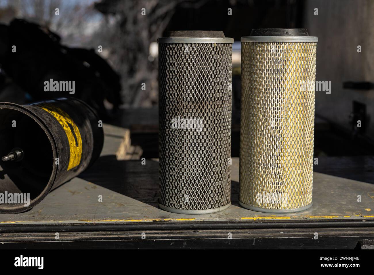 Confronto tra filtro dell'aria vecchio e nuovo di un veicolo industriale o furgone. Filtro a rete metallica con inserto di carta, lato a lato, versione sporca e pulita. Foto Stock