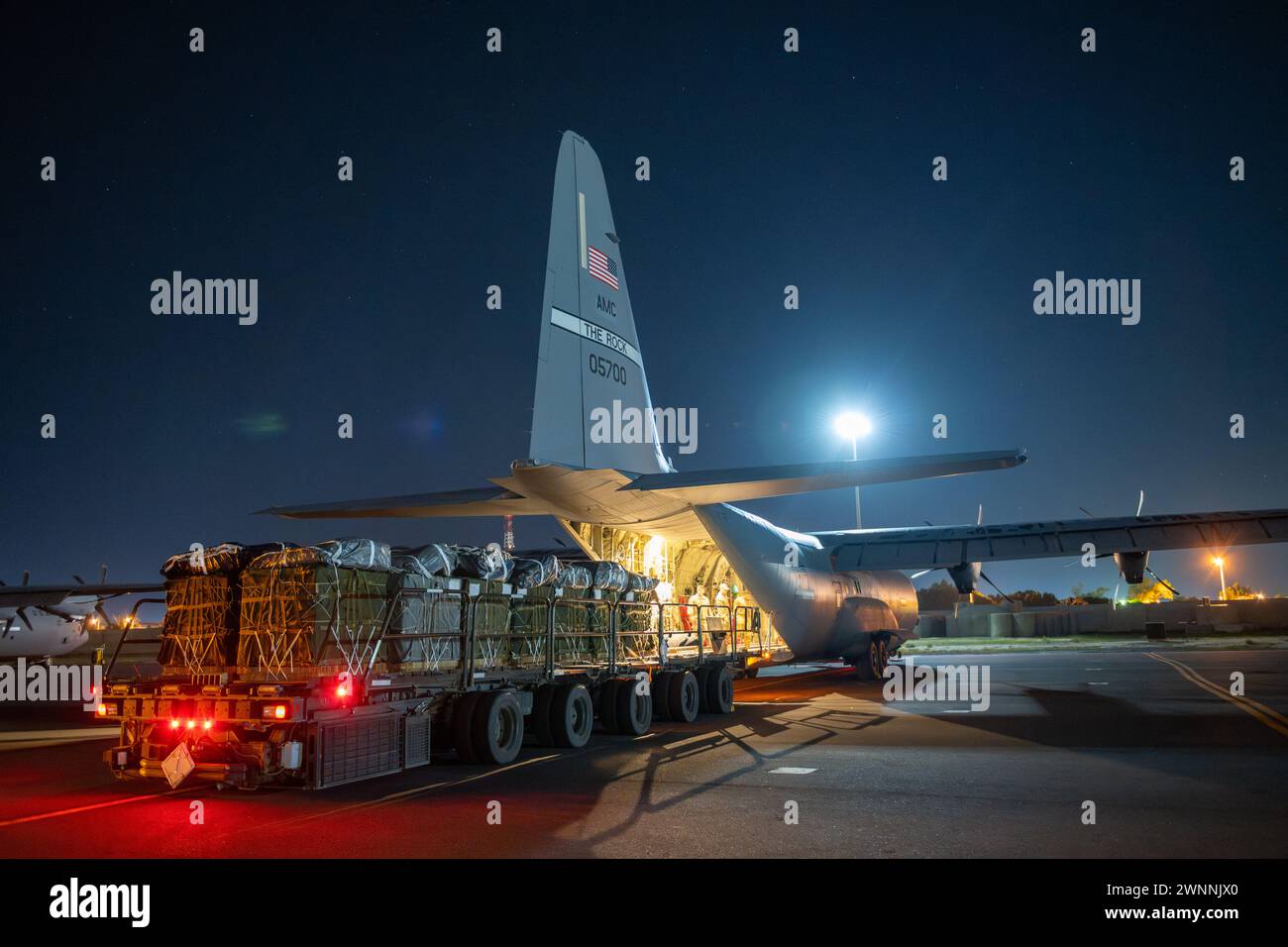 Azraq, Giordania. 1 marzo 2024. Un trasporto merci dell'esercito statunitense carica pallet umanitari nella stiva di carico di un aereo C-130J Super Hercules della U.S. Air Force presso la Muwaffaq salti Air base, 1 marzo 2024, ad Azraq, Governatorato di Zarqa, Giordania. Gli aiuti alimentari saranno lanciati in aria ai rifugiati palestinesi intrappolati dalla guerra israeliana contro Hamas. Credito: TSgt. Christopher Hubenthal/US Airforce Photo/Alamy Live News Foto Stock