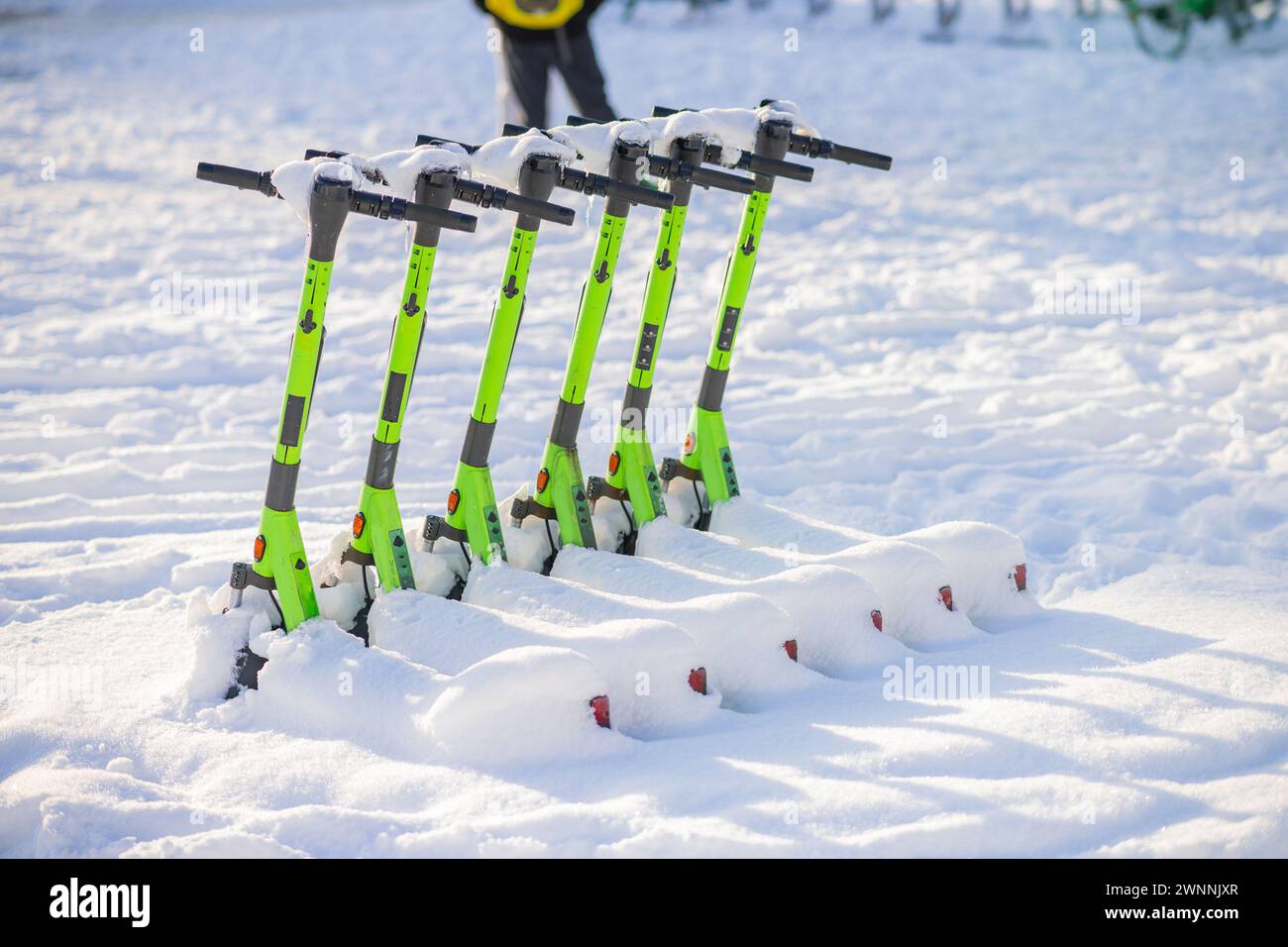 Gli scooter elettrici a noleggio vengono resi inutili a causa della neve pesante e del ghiaccio, che coprono le strade e lo scooter stesso. Situazione invernale a Bergen, Foto Stock