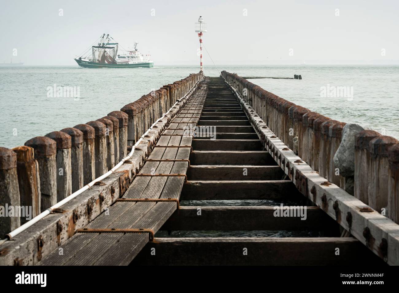 Testa del porto con frangiflutti di pali di legno Foto Stock