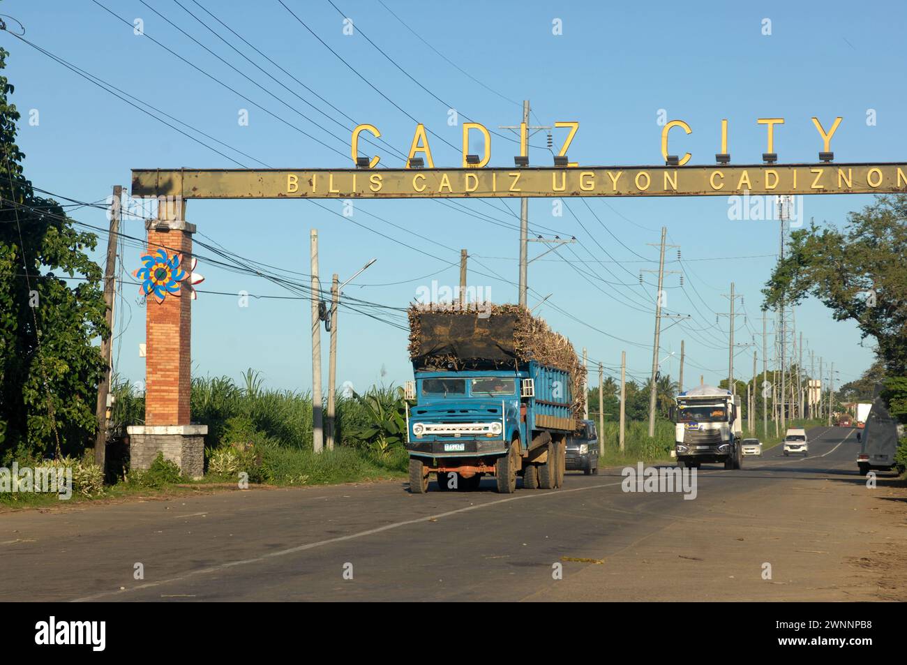 Autocarri sovraccarichi che trasportano il raccolto di canna da zucchero sulla strada da Cadice a Bacolod, Negros Occidental, Filippine. Foto Stock