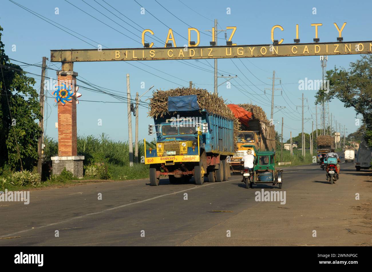 Autocarri sovraccarichi che trasportano il raccolto di canna da zucchero sulla strada da Cadice a Bacolod, Negros Occidental, Filippine. Foto Stock