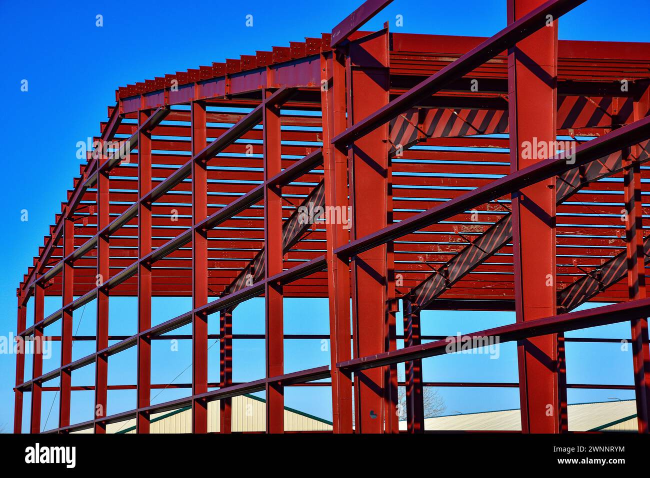 Travi pesanti in acciaio che incorniciano un nuovo edificio commerciale in costruzione. Foto Stock