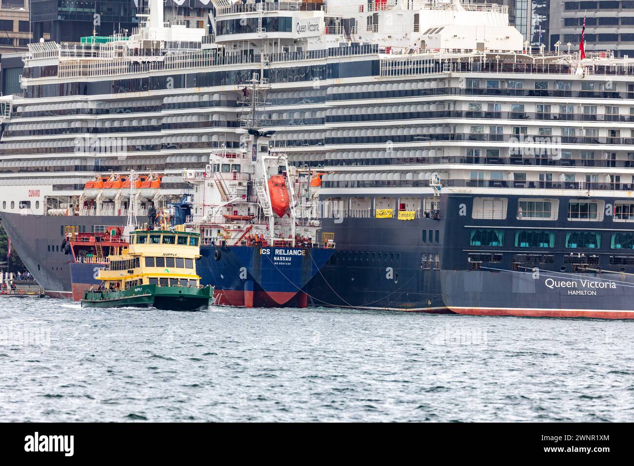 Nave da crociera Queen Victoria a Circular Quay supportata dalla nave petroliera ICS Reliance, traghetto che passa da poppa, Sydney, Australia Foto Stock