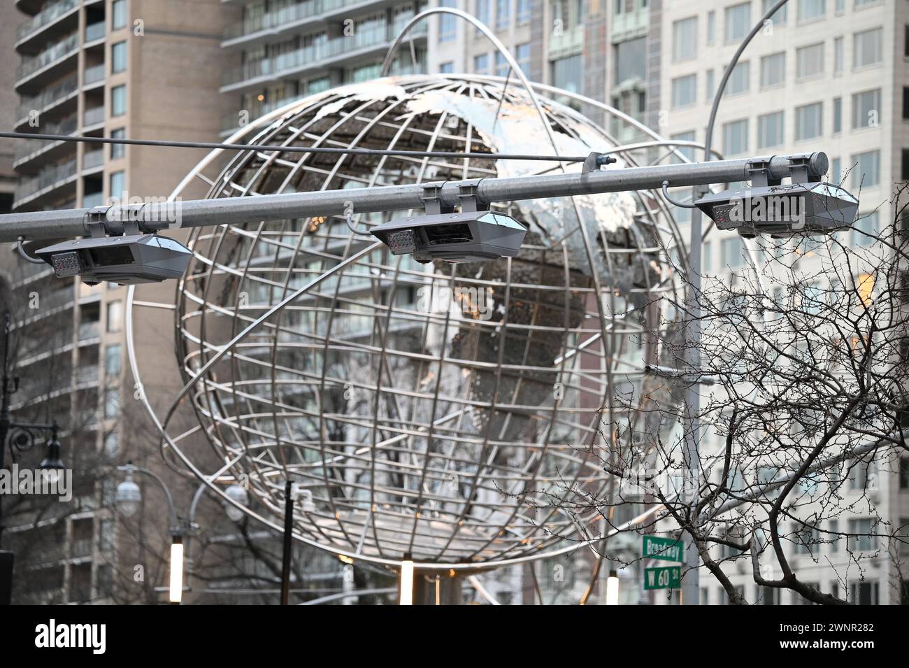 Con la scultura di un globo di Kim Brandell sullo sfondo, un portale di supporto per targa e lettori e-Z Pass sono installati a Broadway, all'incrocio della 60a strada, mentre New York City si prepara ad attuare il "Congestion pricing", che entrerà in vigore all'inizio dell'estate del 2024, New York, New York, 3 marzo 2024. I veicoli passeggeri che viaggiano nel quartiere di Manhattan, New York City, pagherebbero 15 dollari per guidare sotto la 60a strada, una misura progettata per ridurre il traffico, l'inquinamento e i tempi di viaggio, e per fornire fondi, circa 1 miliardo di dollari all'anno, per l'MTA, denaro che non sarà condiviso con l'ic Foto Stock