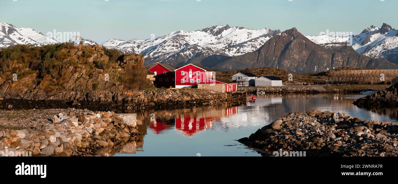Laukvik, Isole Lofoten, Norvegia, barche da pesca nel porto al sole di mezzanotte, montagna con neve sullo sfondo Foto Stock