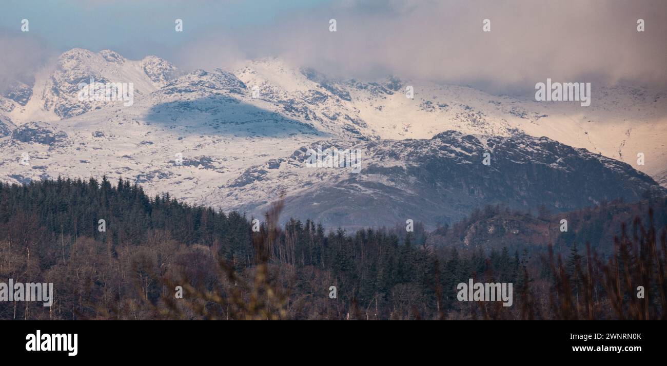 Cumbria, Regno Unito. 4 marzo 2024. Meteo nel Regno Unito. Gelata e giornate limpide e soleggiate e fredde la neve ha ricoperto alte colline sopra e intorno al lago Windermere, nella Cumbria meridionale, il Lake District . Crediti: Gordon Shoosmith/Alamy Live News Foto Stock