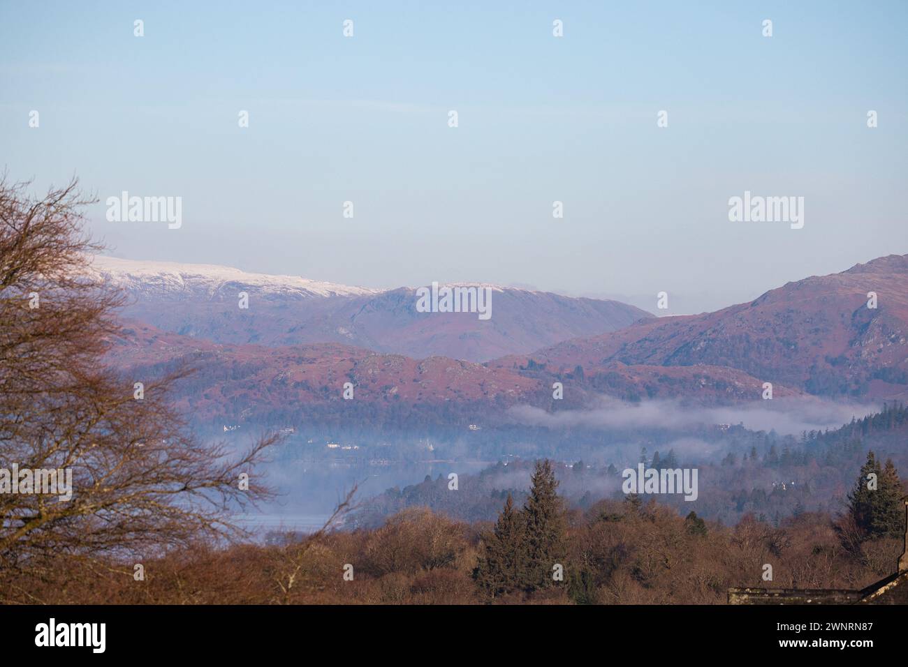 Cumbria, Regno Unito. 4 marzo 2024. Meteo nel Regno Unito. Gelata e giornate limpide e soleggiate e fredde la neve ha ricoperto alte colline sopra e intorno al lago Windermere, nella Cumbria meridionale, il Lake District . Crediti: Gordon Shoosmith/Alamy Live News Foto Stock