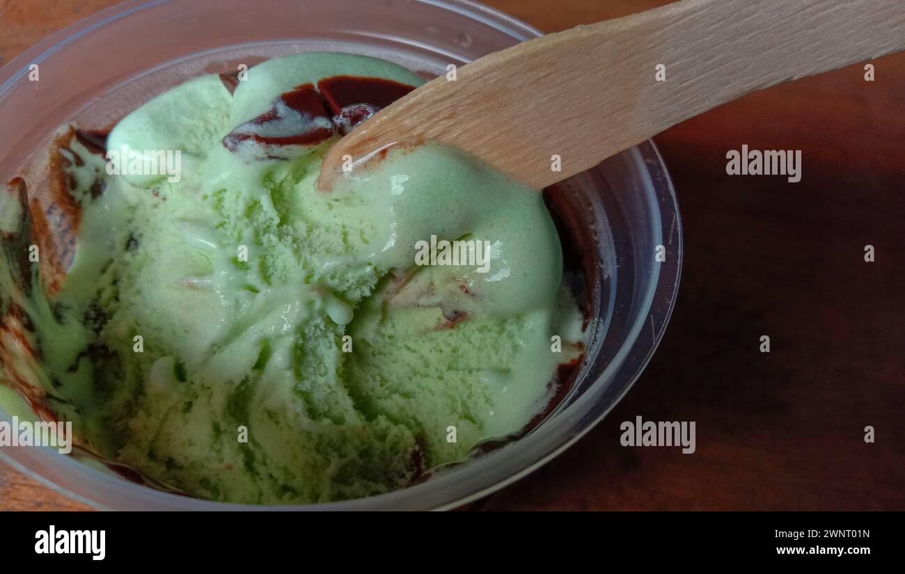 La foto è una foto di gelato al gusto di avocado in una tazza con sfondo nero Foto Stock