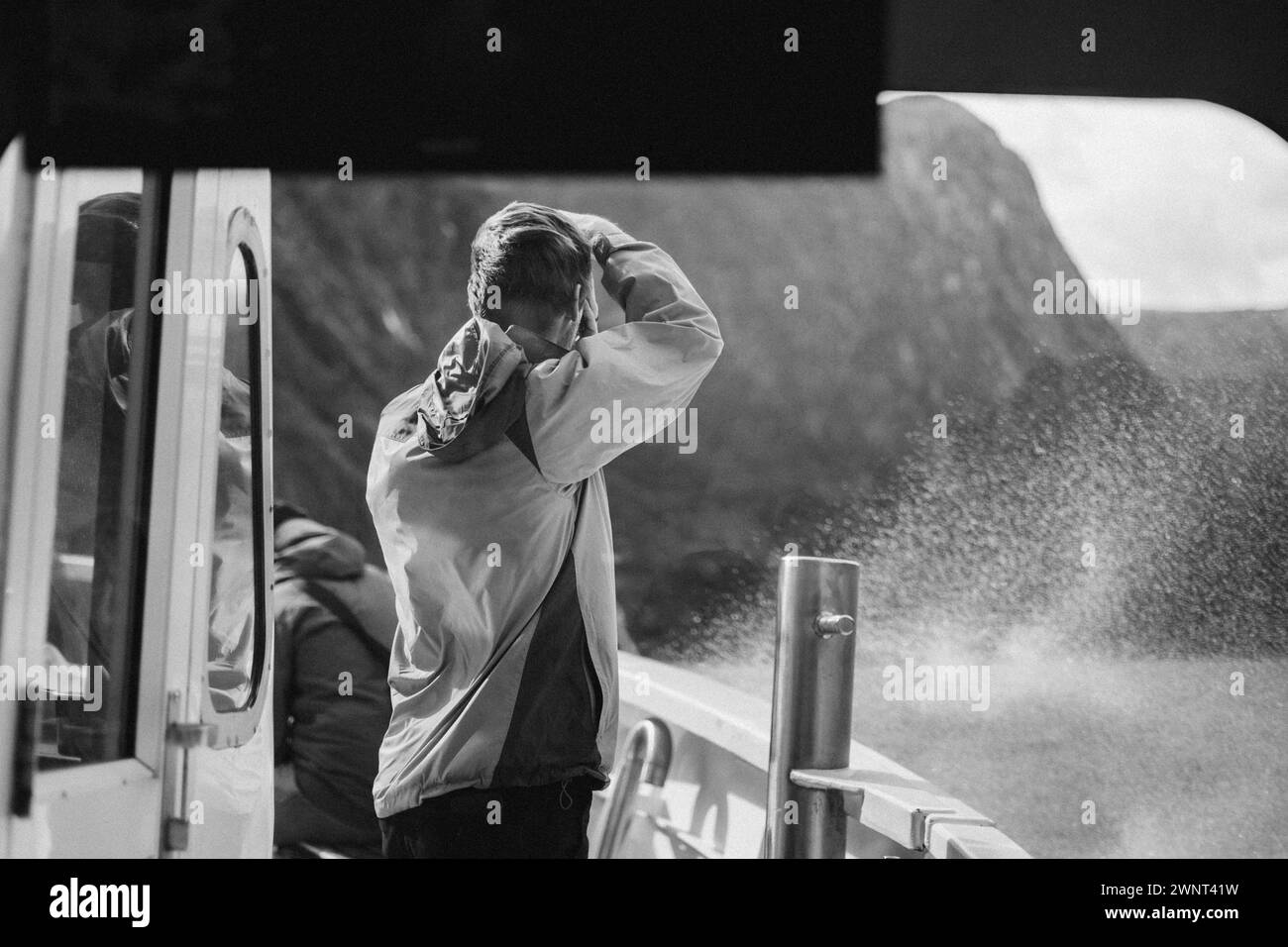 Il turista scatta una foto durante un tour in barca a Milford Sound Foto Stock