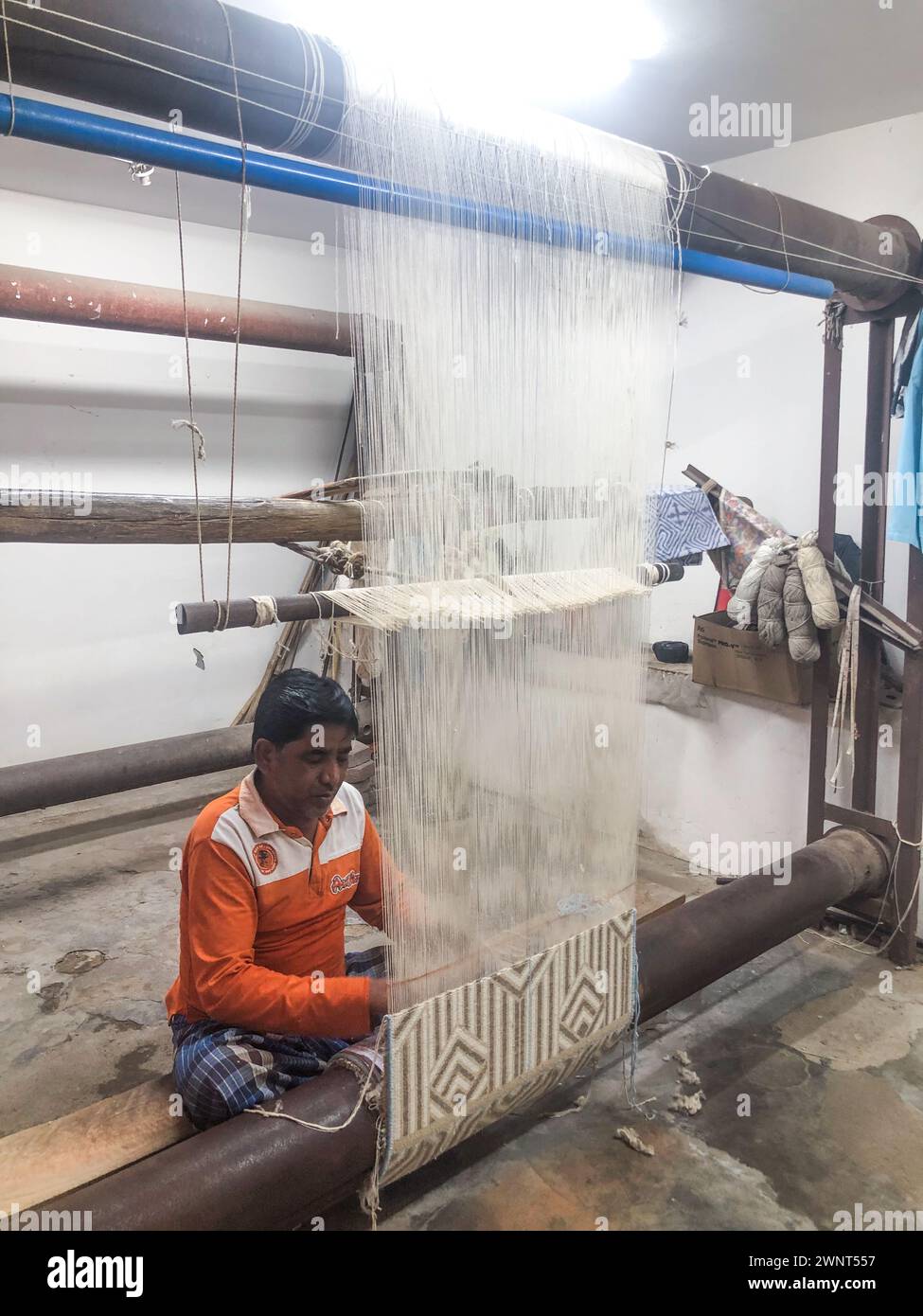 Agra, India - 18 febbraio 2024: tessitrice di tappeti che lavora nello stabilimento in India vicino ad Agra. Foto Stock