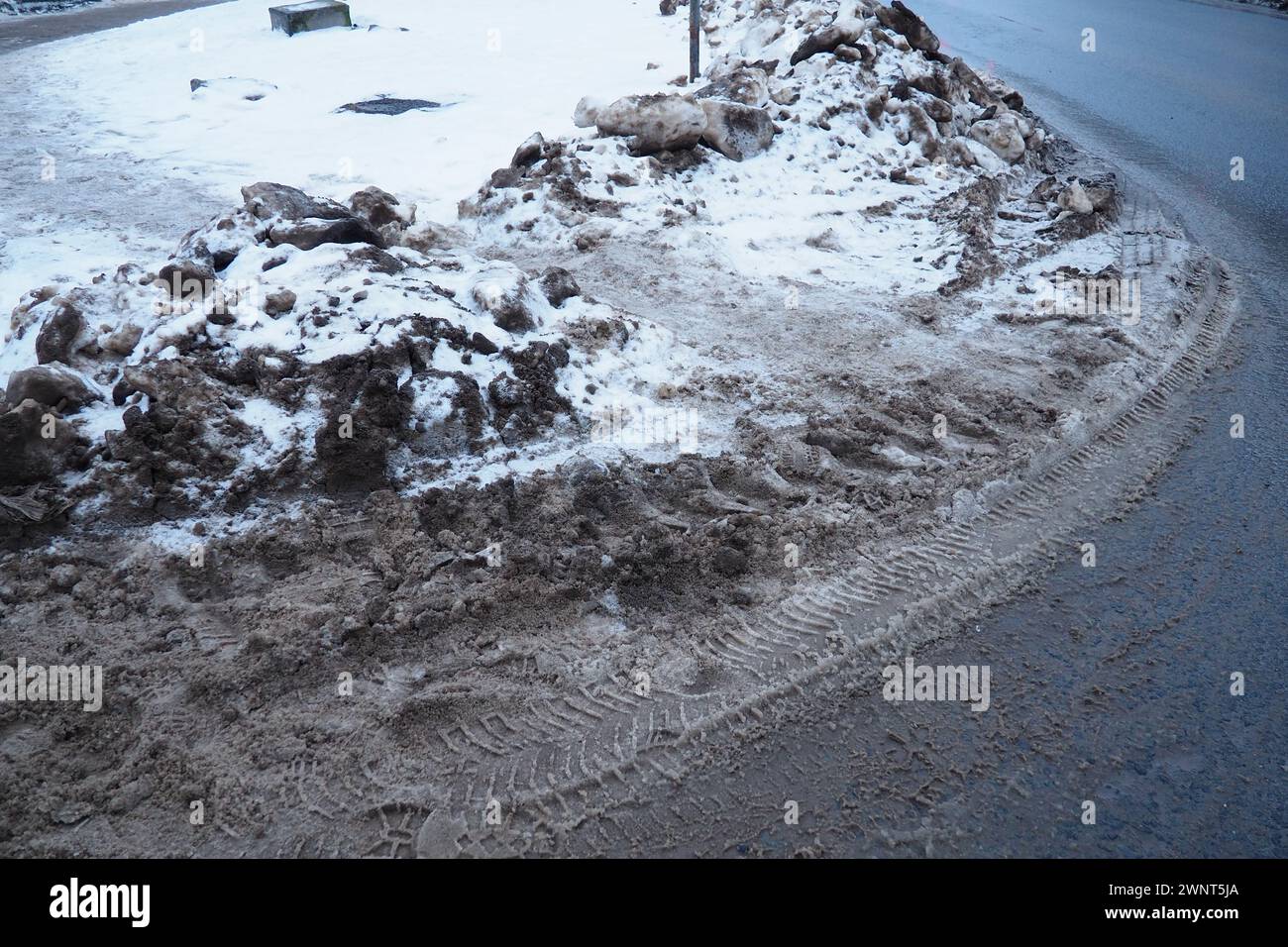 Neve, ghiaccio, fango e fango invernale in una traversata pedonale. La temperatura dell'aria è di circa 0. Condizioni di guida difficili. Distanza di frenata della vettura Foto Stock