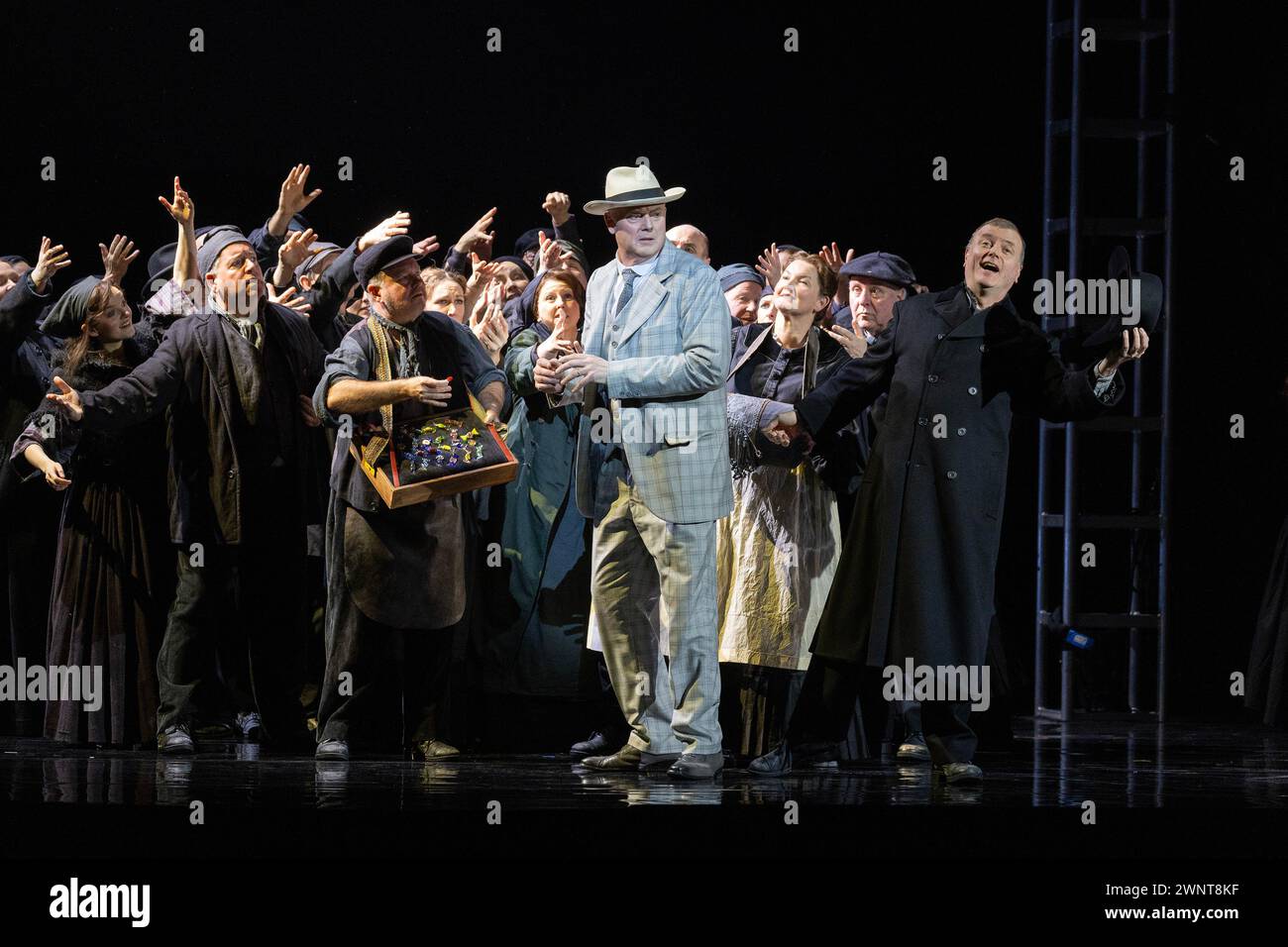 Lo scrittore e turista tedesco Gustav von Aschenbach (centro - cantato da Mark le Brocq) con venditori di strada veneziani nell'opera DEATH IN VENICE di Benjamin Britten al Welsh National Opera, inaugurazione al Wales Millennium Centre di Cardiff il 7 marzo 2024. Cinquantuno anni dopo la prima dell'opera ad Aldeburgh questa nuova produzione è diretta da Olivia Fuchs e successivamente tour a Llandudno, Southampton, Oxford, Bristol e Birmingham. Foto Stock