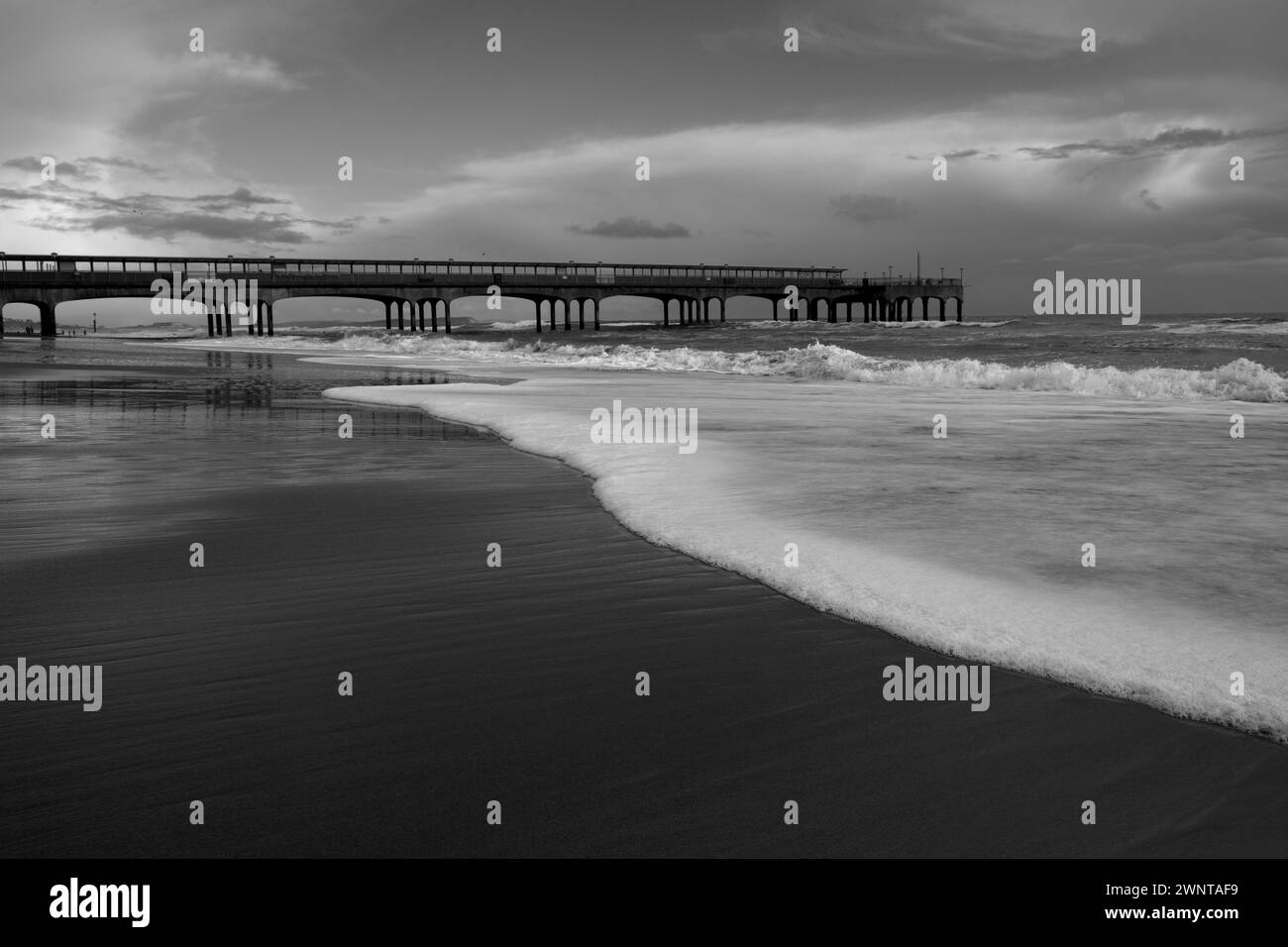 Bella immagine in bianco e nero di Boscombe Pier con surf break sulla spiaggia. Include spazio per il testo. Formato orizzontale Foto Stock