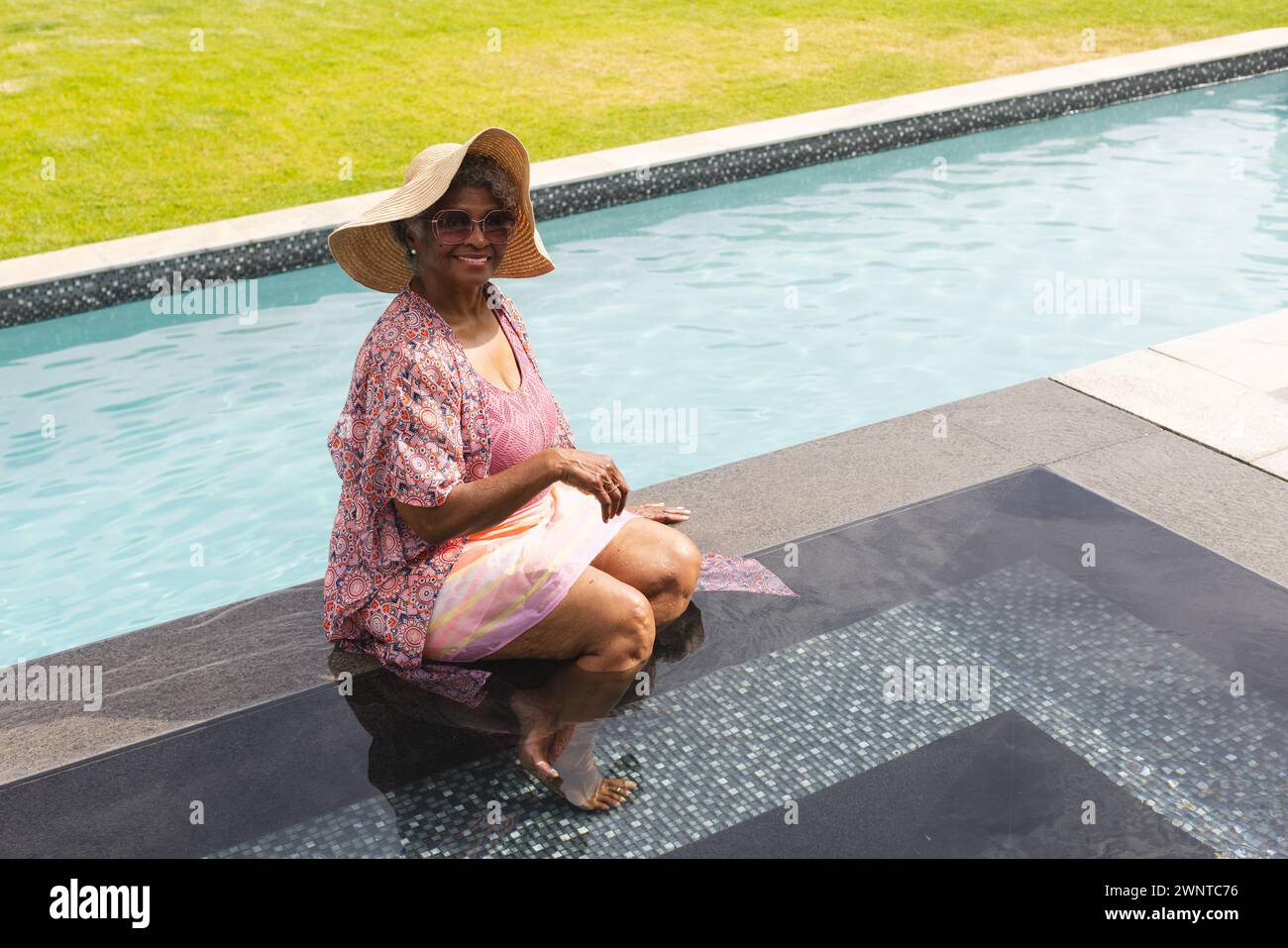 Una donna birazziale senior gode di relax a bordo piscina, con spazio per fotocopie Foto Stock