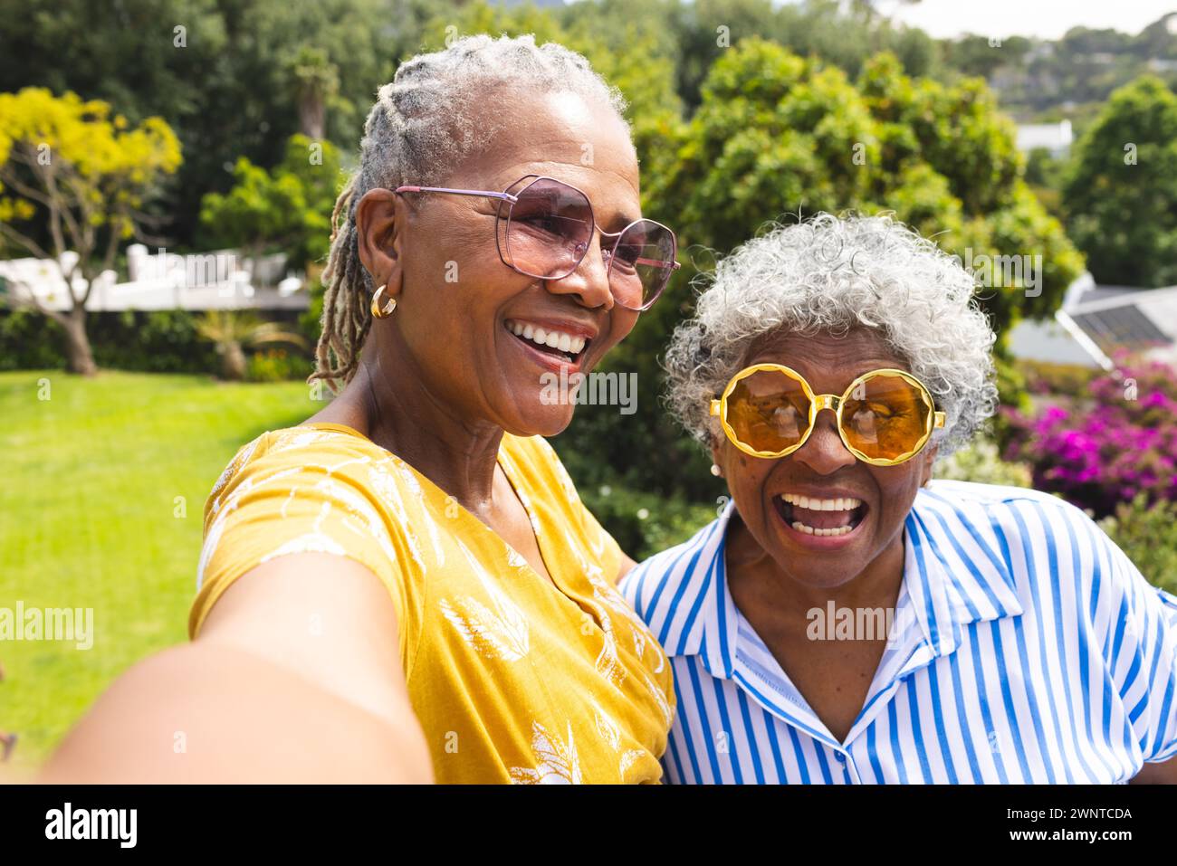 La donna afroamericana anziana e la donna birazziale senior condividono un momento di gioia all'aperto Foto Stock