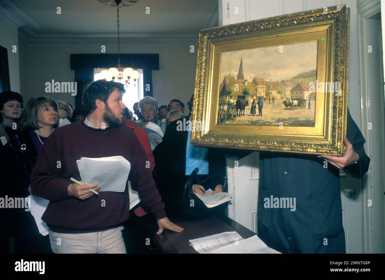 Monkstown, Dublino, Eire 1981. Un'asta d'arte locale, vendita di dipinti d'arte irlandesi all'inizio del boom dei prezzi dell'arte irlandese. Gli spettatori ispezionano un dipinto ad olio del XIX secolo. Irlanda degli anni '1980. HOMER SYKES Foto Stock
