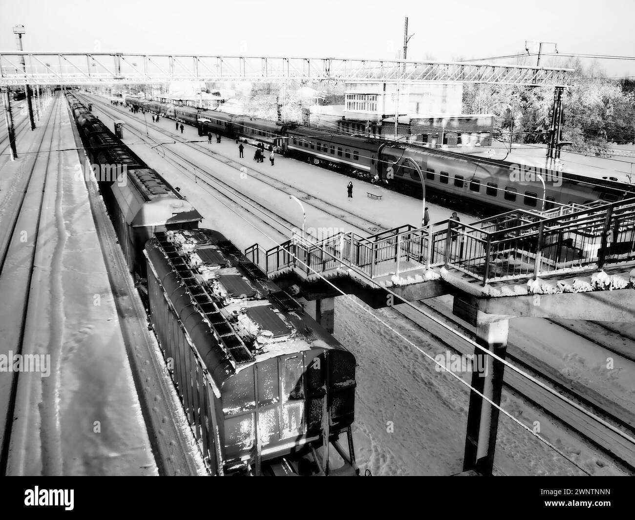 Svir, Russia,01.02.24: Stazione ferroviaria di Svir sulla ferrovia Oktyabrskaja. Treni merci passeggeri su rotaia. Persone e passeggeri camminano lungo il Foto Stock