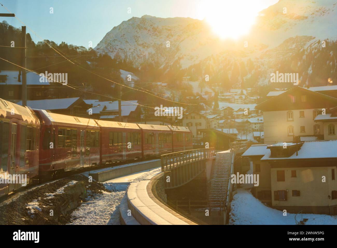 Treno passeggeri rosso sulla ferrovia Retica nel Canton Graubunden, Svizzera in inverno Foto Stock