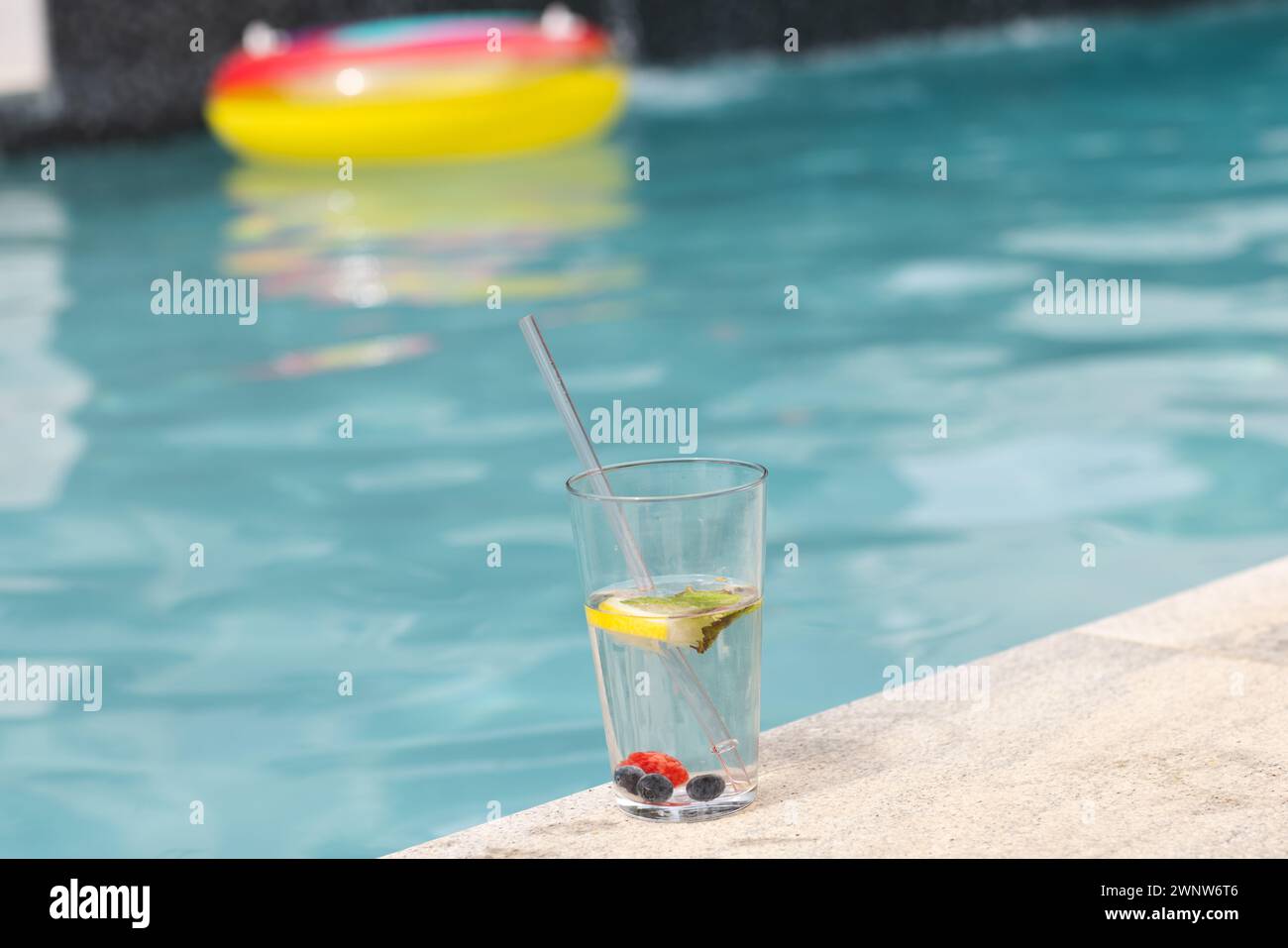 Una bevanda rinfrescante con lime e frutti di bosco si trova a bordo piscina con spazio per le copie Foto Stock