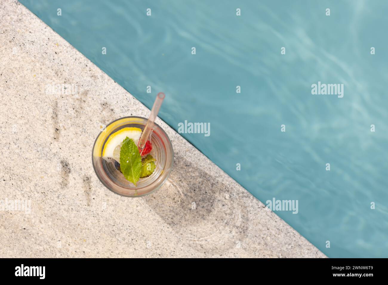 Una bevanda rinfrescante con limone e menta si trova a bordo piscina con spazio per le copie Foto Stock