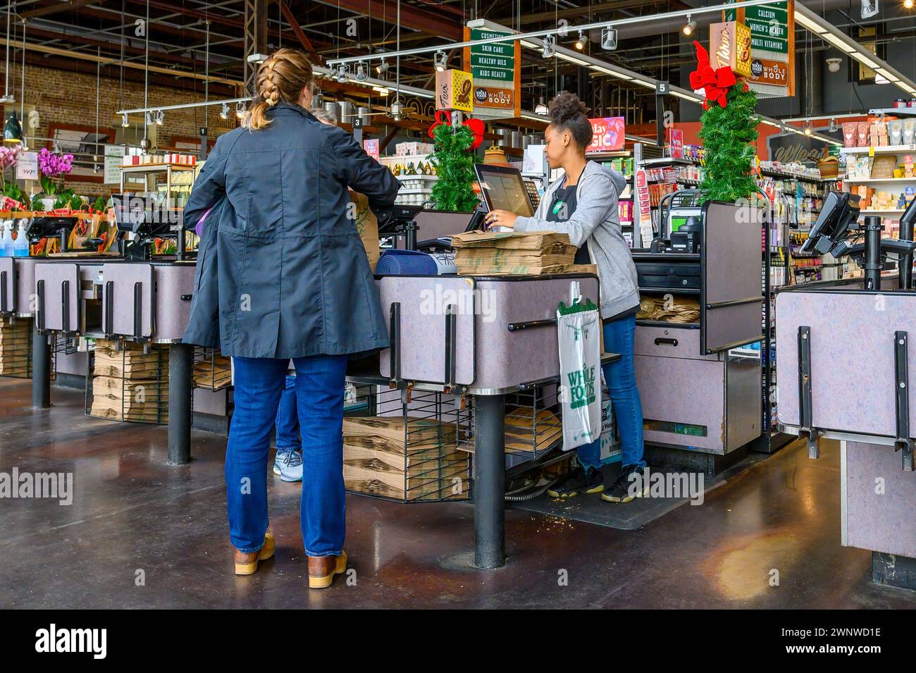 NEW ORLEANS, LOUISIANA, USA - 5 DICEMBRE 2023: Banco cassa con cassiere e clienti nel negozio di alimentari Uptown Whole Foods Foto Stock