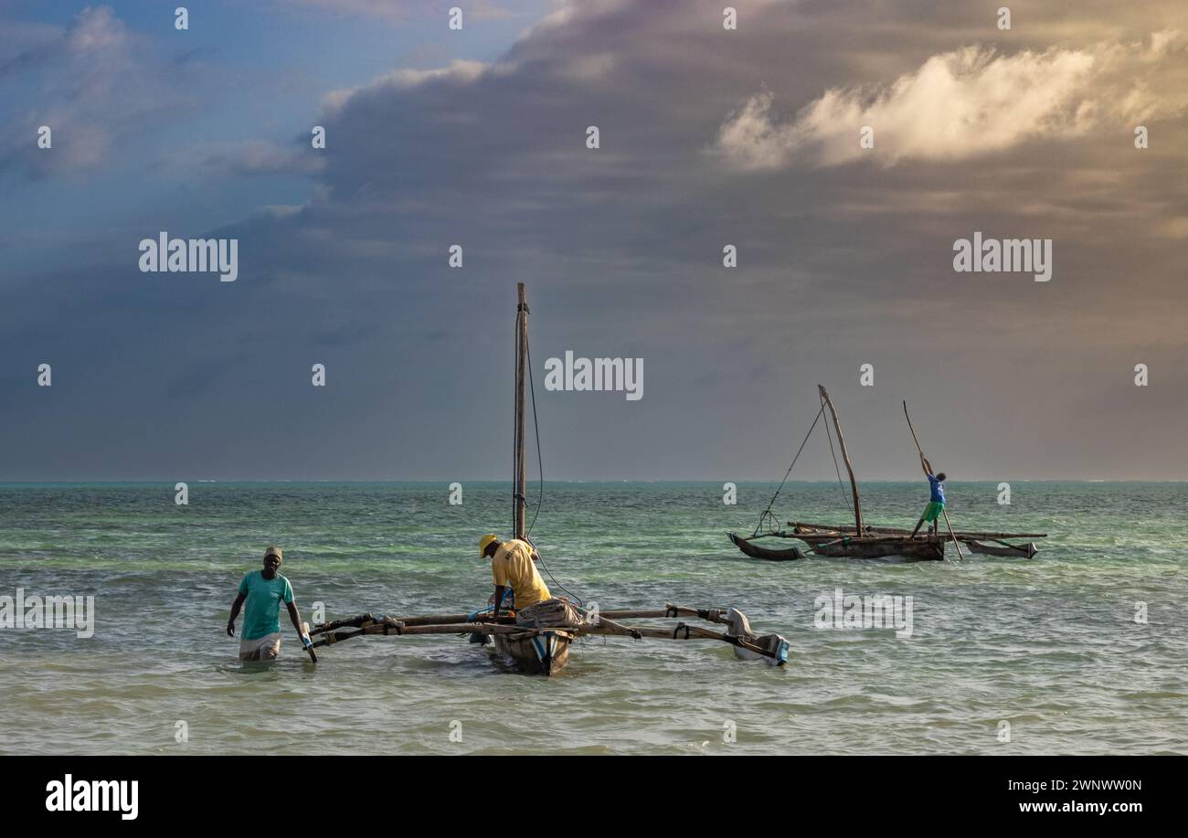 Pescatori con le loro tradizionali barche in dhow in legno, Jambiani Beach, Zanzibar, Tanzania Foto Stock