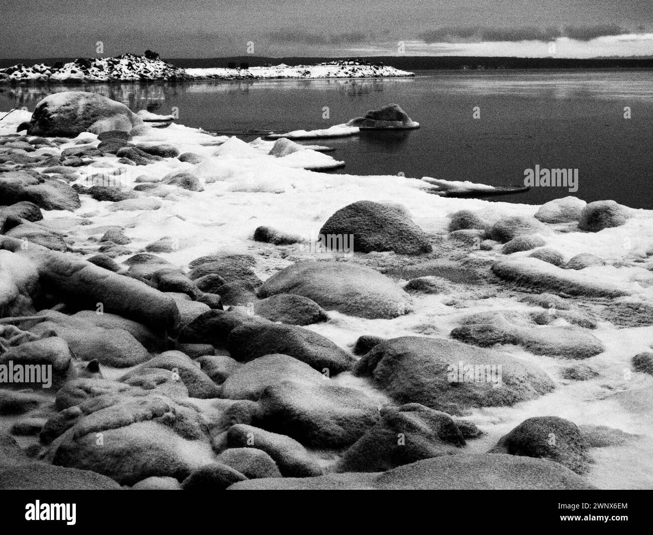 Spettacolare ghiaccio artico, stile retrò e vintage. Una fotografia in bianco e nero con grana maggiore. Pietre, neve, ghiaccio, acqua e cielo spettacolare. Inverno Foto Stock