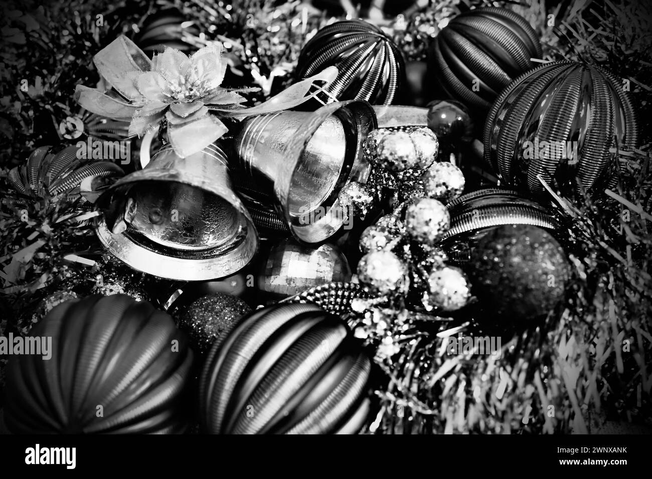 Sfondo natalizio con decorazioni natalizie, palle natalizie, campane, fiocchi, tinsel natalizio. Buon anno e buon Natale. Bianco e nero Foto Stock