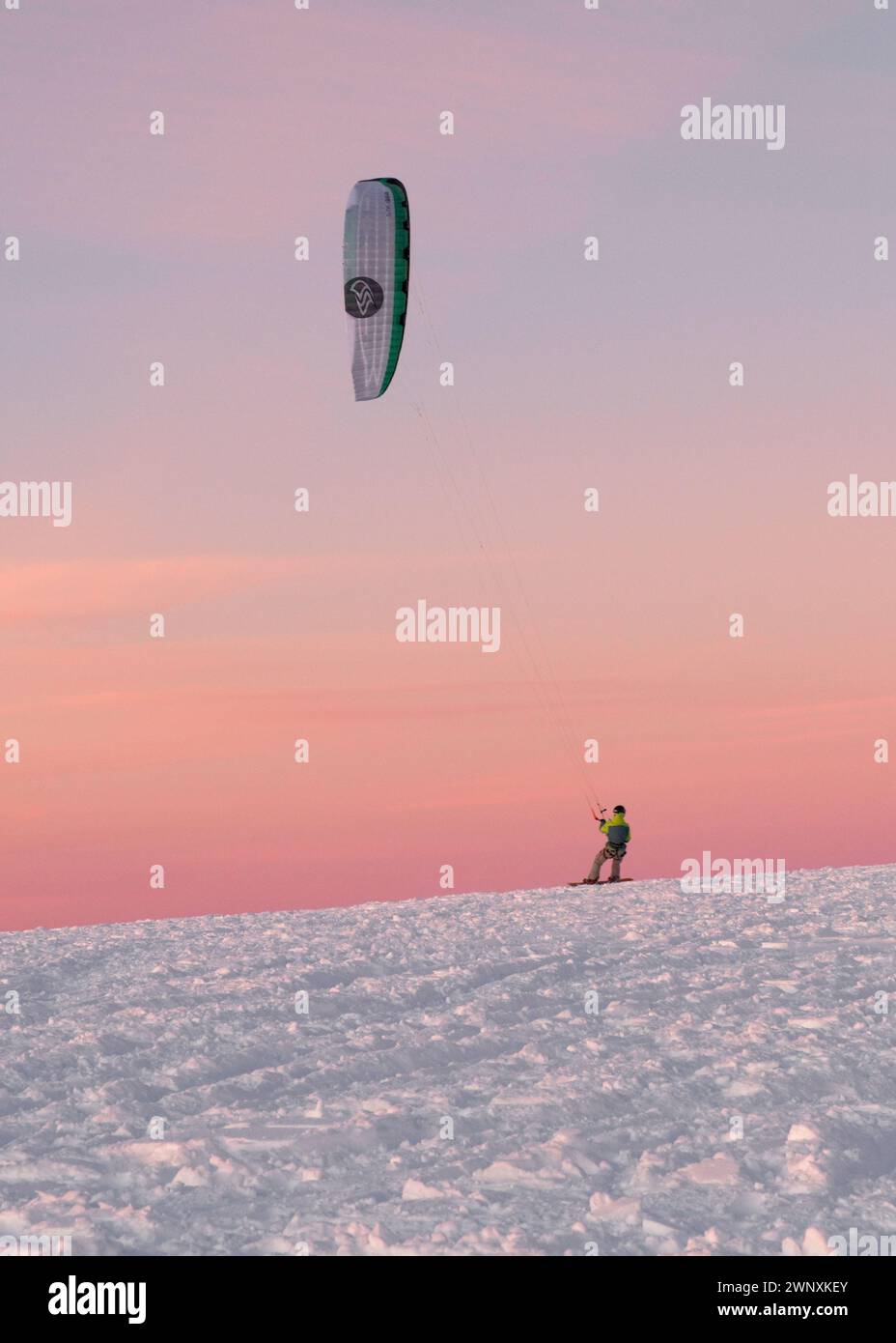 Uomo neve che kite sotto un bel cielo rosa Foto Stock
