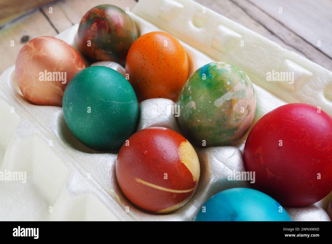 Le uova di Pasqua colorate si chiudono in una confezione di plastica. Dieci colorate uova natalizie sono impilate l'una vicino all'altra. Uova di pollo bollite con fiori e. Foto Stock