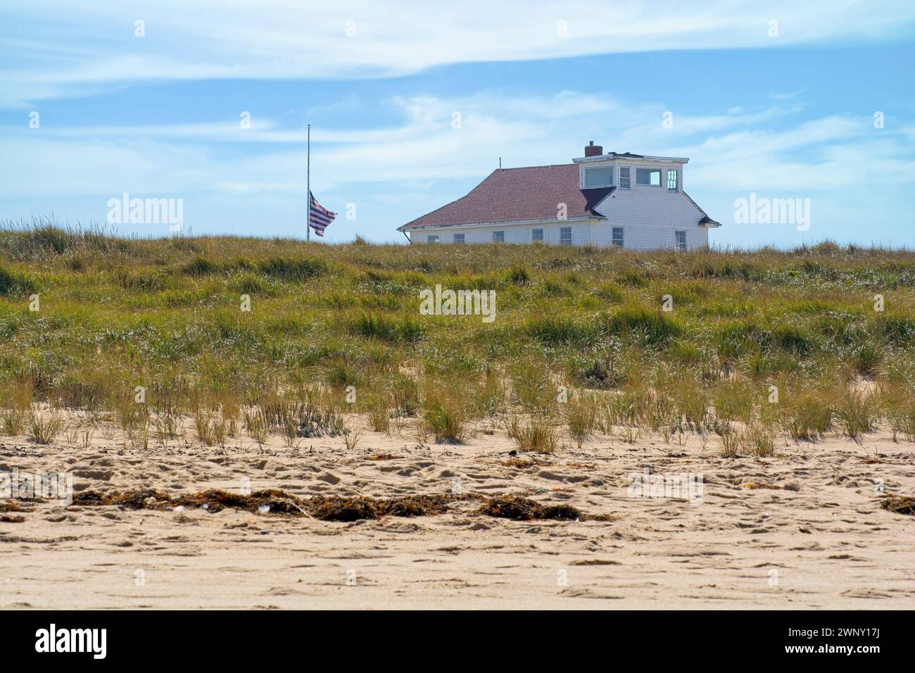 Stazione Oversand Permit presso la spiaggia di Race Point, sulle dune di sabbia. Costruito nel 1888 per il servizio di salvataggio come stalla per i soccorsi di relitti costieri. Bandiera degli Stati Uniti Foto Stock