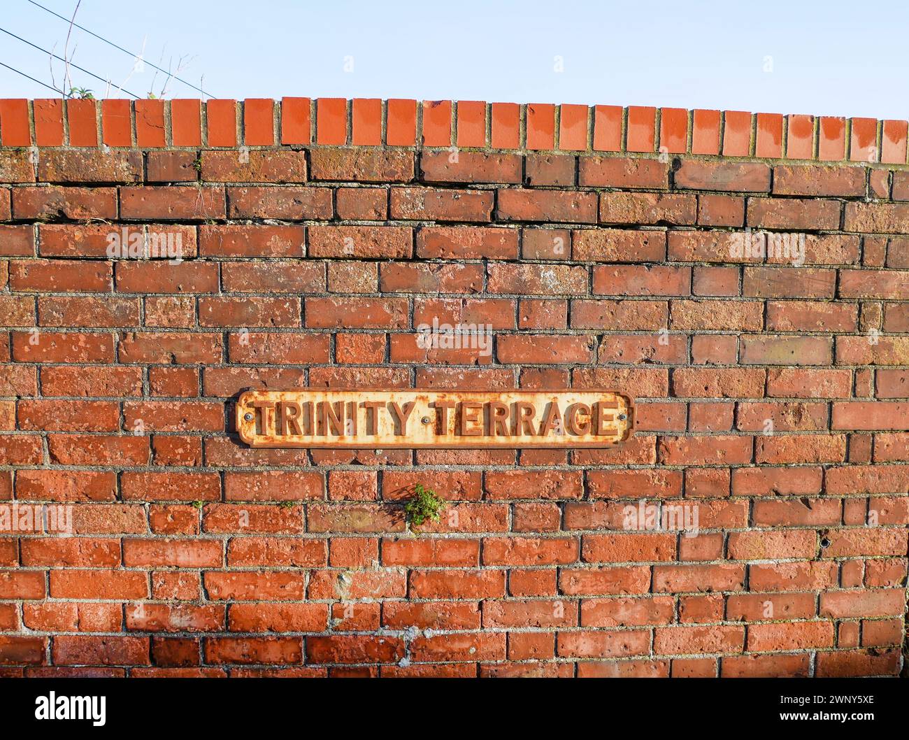 Nome della strada Trinity Terrace su un vecchio muro di mattoni nella città di Weymouth, Dorset, Inghilterra. Foto Stock