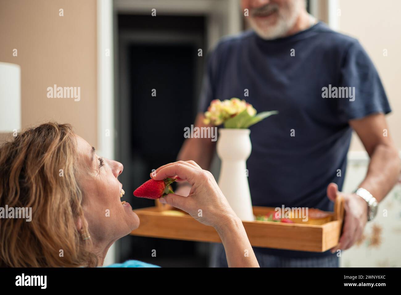 Questa accattivante immagine ci porta vicino a un momento sereno nella routine mattutina di una coppia anziana in pensione. L'attenzione e' sulla donna, che e' del Foto Stock