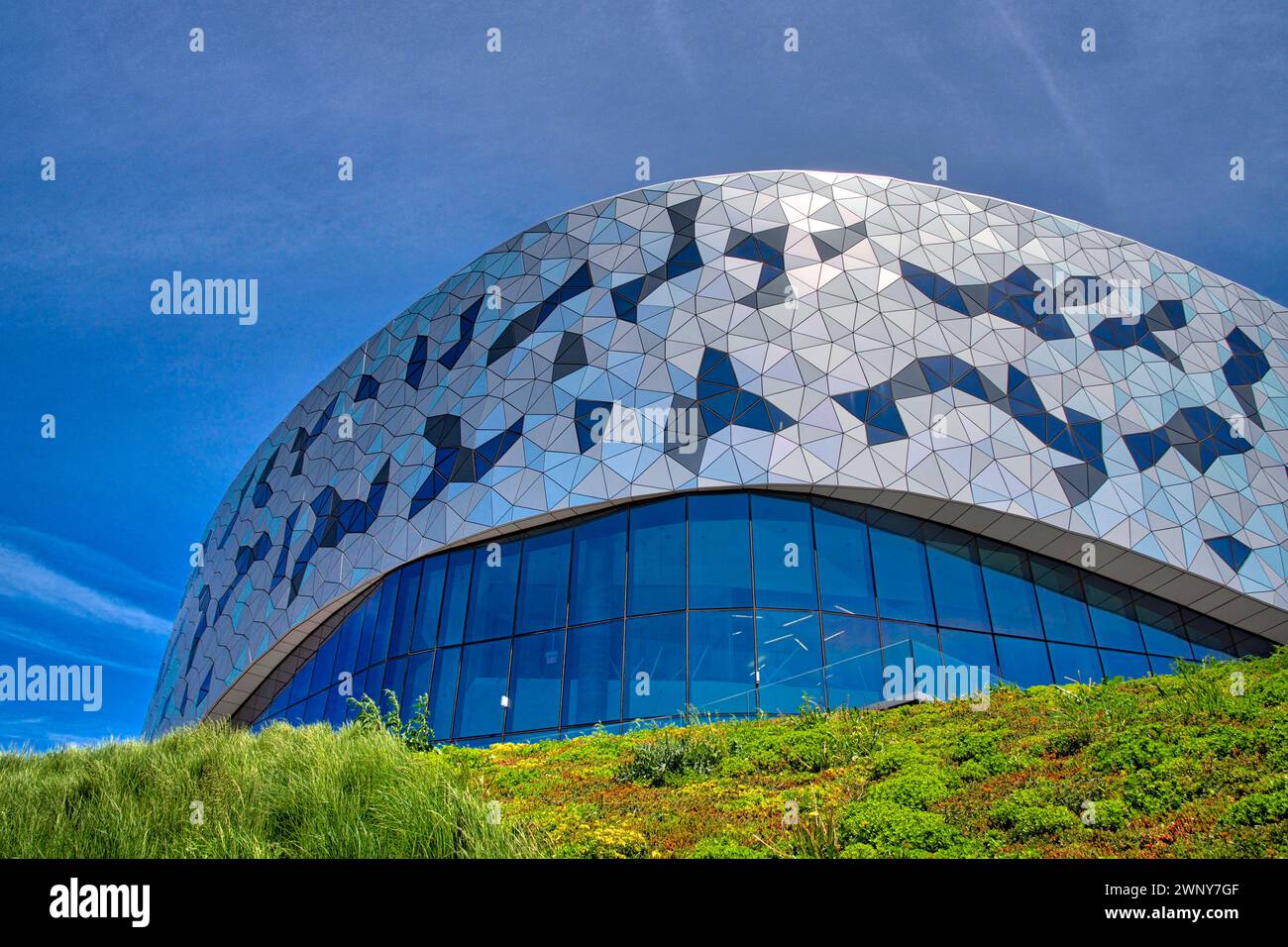 Vista ad angolo basso di un'architettura dal design moderno dell'edificio a parete con finestre di vetro Foto Stock