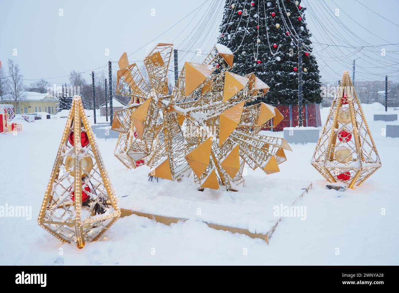 Petrozavodsk, Russia, 10 gennaio 2024: Piccole forme architettoniche sotto forma di coni luminosi e un grande cono, fatto di ghirlande e lampadine Foto Stock