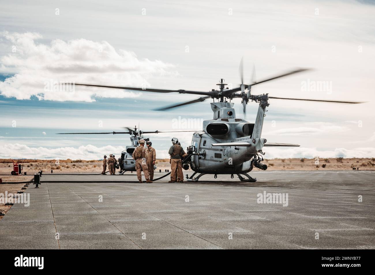 US Marines with Marine Light Attack Helicopter Squadron (HMLA) 267, Marine Aircraft Group 39, 3D Marine Aircraft Wing, rifornire un UH-1Y Venom a supporto di un'esercitazione di combattimento della Marine Air-Ground Task Force durante l'esercitazione di addestramento del livello di servizio 2-24 a Camp Wilson, Marine Corps Air-Ground Combat Center, Twentynine Palms, California, 19 febbraio 2024. MWX è l'evento culminante per SLTE 2-24 che migliora le capacità operative e la letalità dei membri dei servizi degli Stati Uniti e degli alleati come MAGTF. (Foto del corpo dei Marines degli Stati Uniti di Lance Cpl. Richard PerezGarcia) Foto Stock