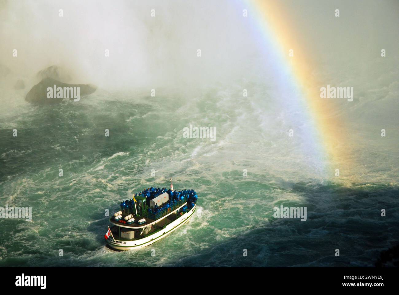 Il tour in barca Maid of the Mist si dirige verso le cascate del Niagara mentre un arcobaleno si sviluppa nella nebbia. Foto Stock