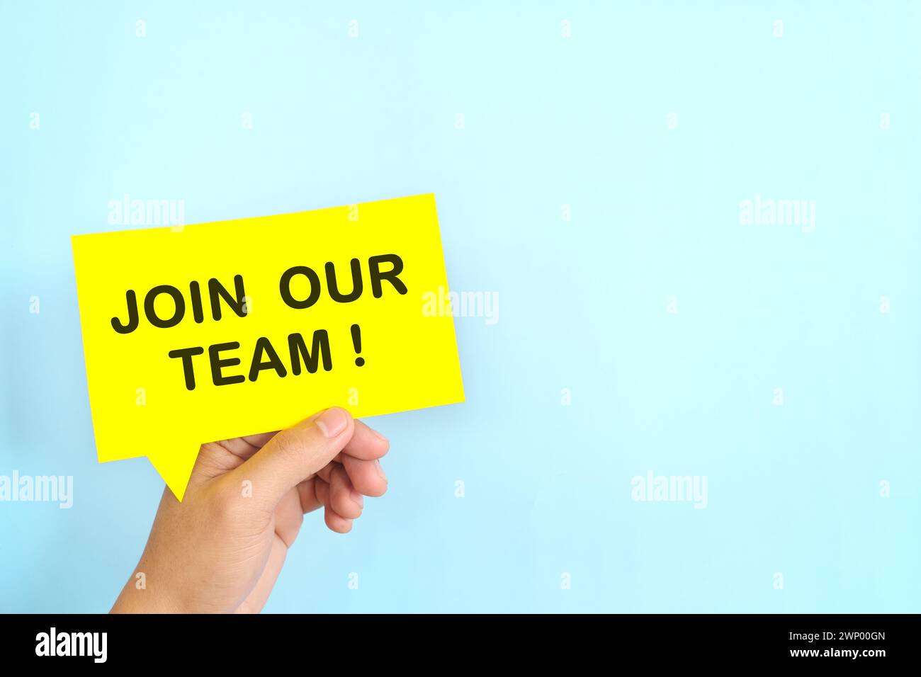 Mano umana che tiene la bolla gialla con una frase scritta Unisciti a noi o unisciti al nostro team. Concetto di assunzione e assunzione di lavoro. Foto Stock