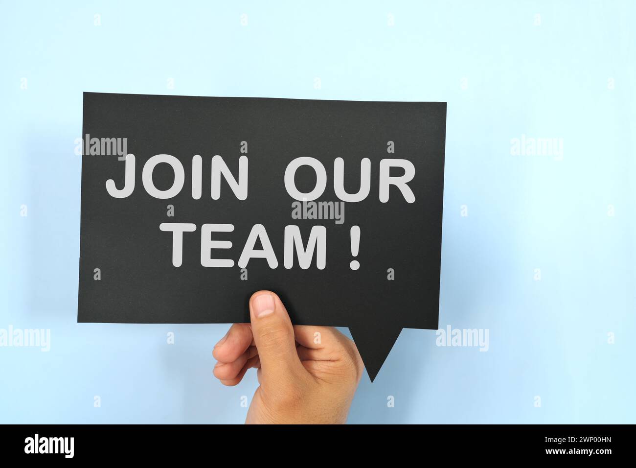 Mano umana che tiene la bolla gialla con una frase scritta Unisciti a noi o unisciti al nostro team. Concetto di assunzione e assunzione di lavoro. Foto Stock