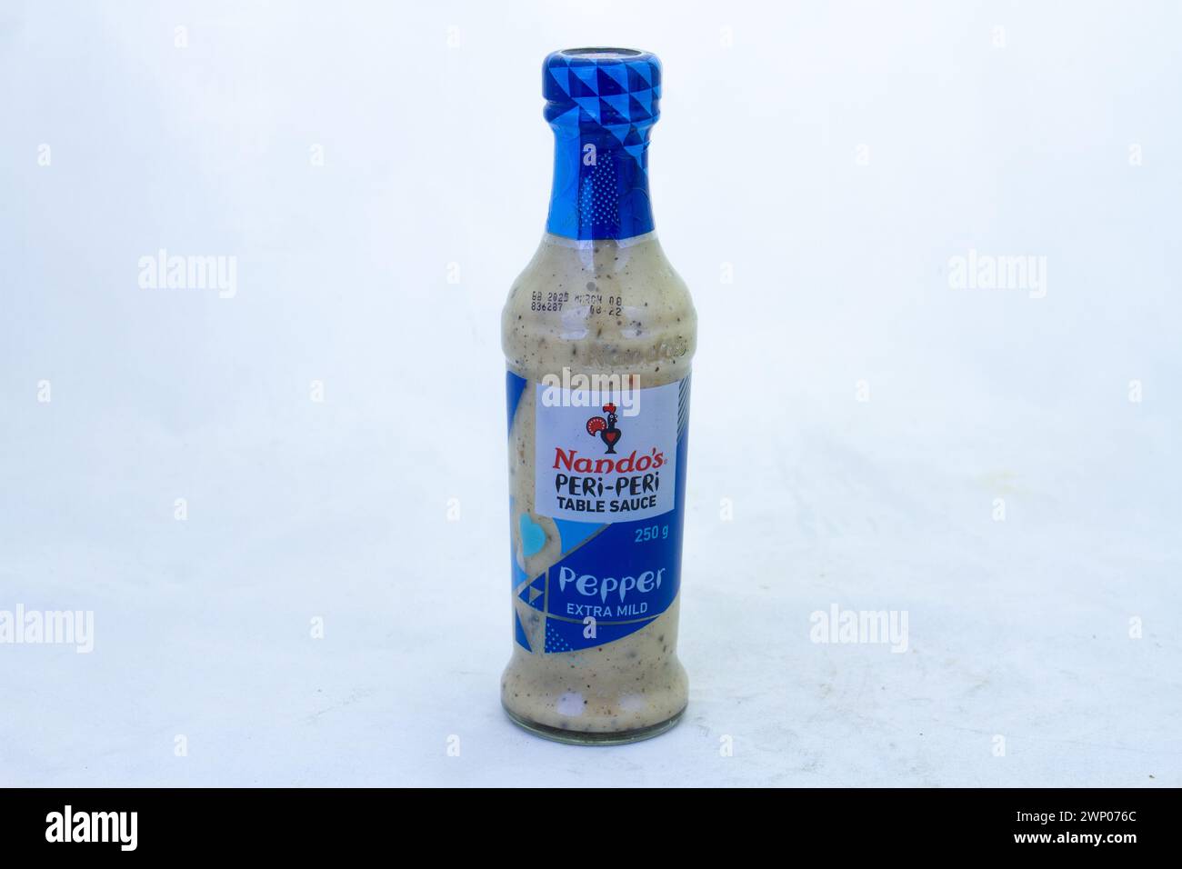 Johannesburg, Sud Africa - una bottiglia di salsa al pepe peri di Nando isolata su uno sfondo chiaro con spazio di copia in formato orizzontale Foto Stock