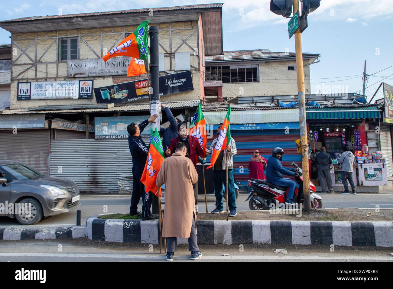 Srinagar, India. 4 marzo 2024. I sostenitori del partito al governo indiano Bharatiya Janata Party (BJP) installano le bandiere del partito prima della visita del primo ministro indiano Narendra modi a Srinagar nel Kashmir il 7 marzo. La sicurezza è stata messa in allerta in tutto il Jammu e il Kashmir prima della prima visita di Narendra modi nella valle dopo l'abrogazione dell'articolo 370 nel 2019, ponendo fine allo status speciale di semi-autonoma della regione. (Foto di Faisal Bashir/SOPA Images/Sipa USA) credito: SIPA USA/Alamy Live News Foto Stock