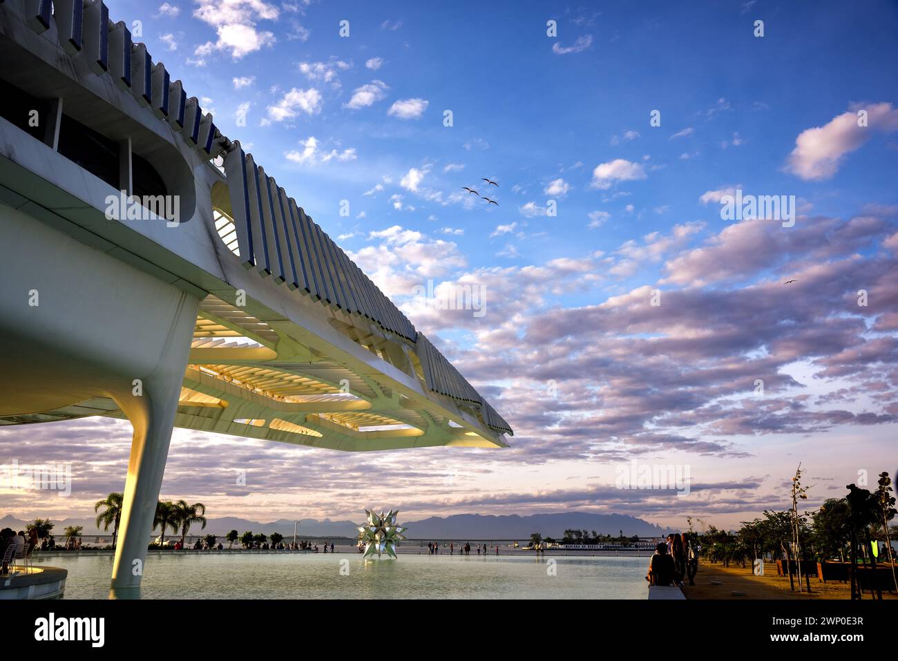 Tramonti sopra la struttura e la piscina riflettente del Museo del domani a Rio de Janeiro, Brasile Foto Stock