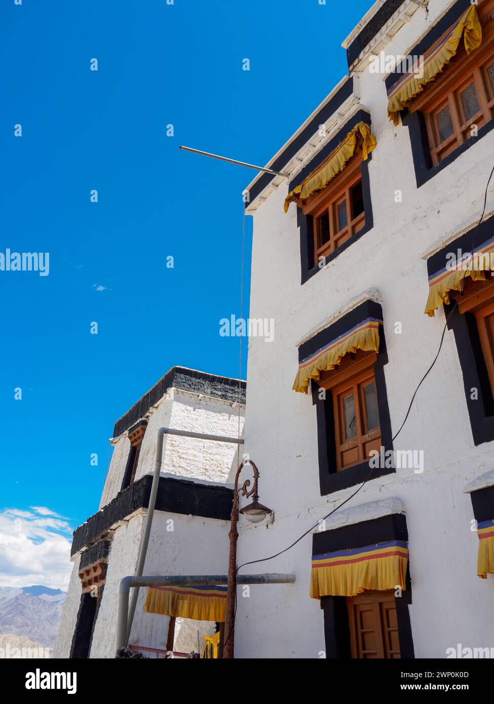 Vecchi edifici in stile architettonico tibetano del Monastero di Namgyal Tsemo Gompa, finestre di colore che contrastano in modo attraente con pareti bianche. Foto Stock