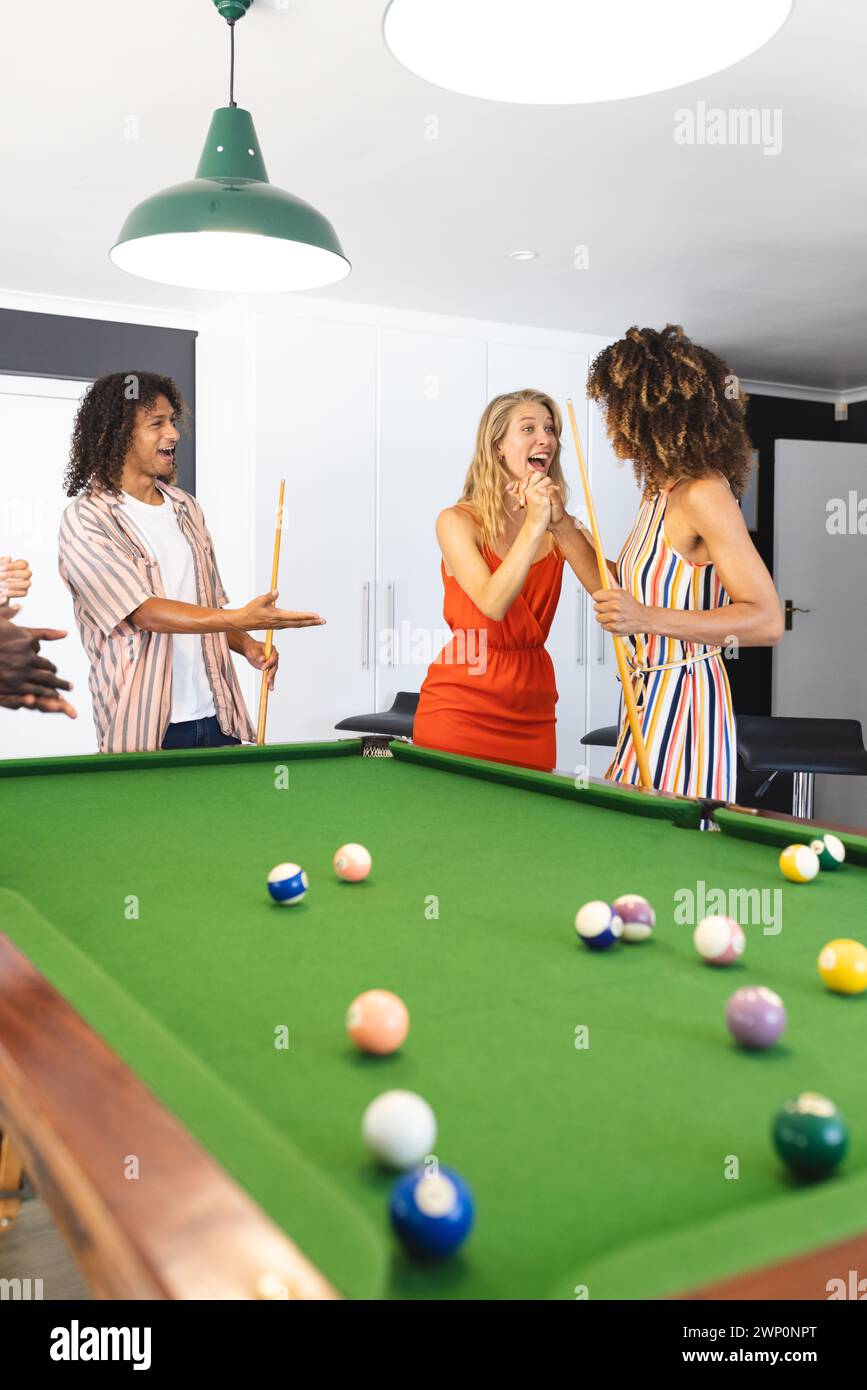 Gruppi di amici diversi si divertono a giocare a biliardo in una stanza luminosa Foto Stock