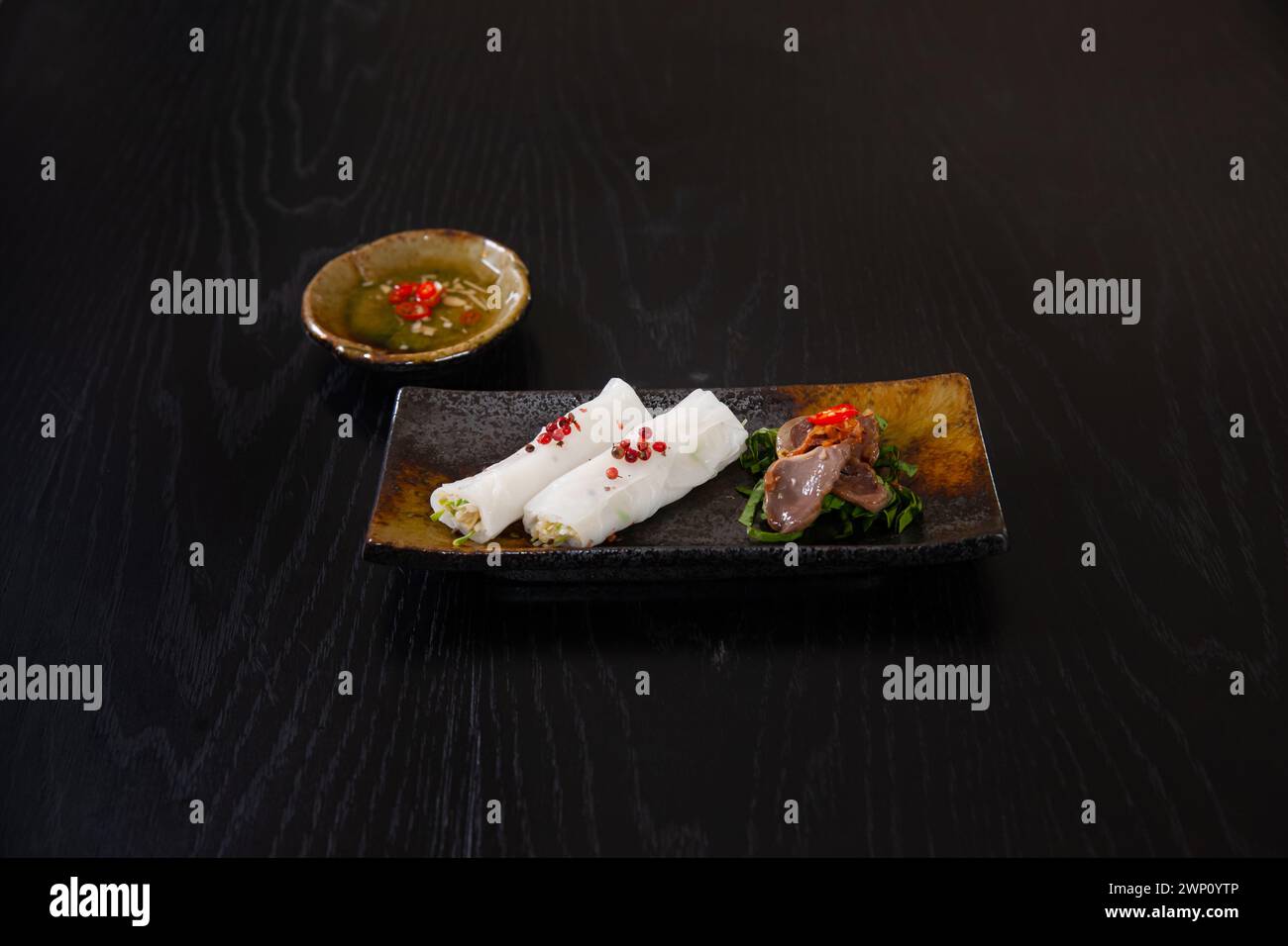 Banh uot Long ga, torta di riso bagnata con giblet di pollo, cibo vietnamita isolato su sfondo nero da tavola Foto Stock