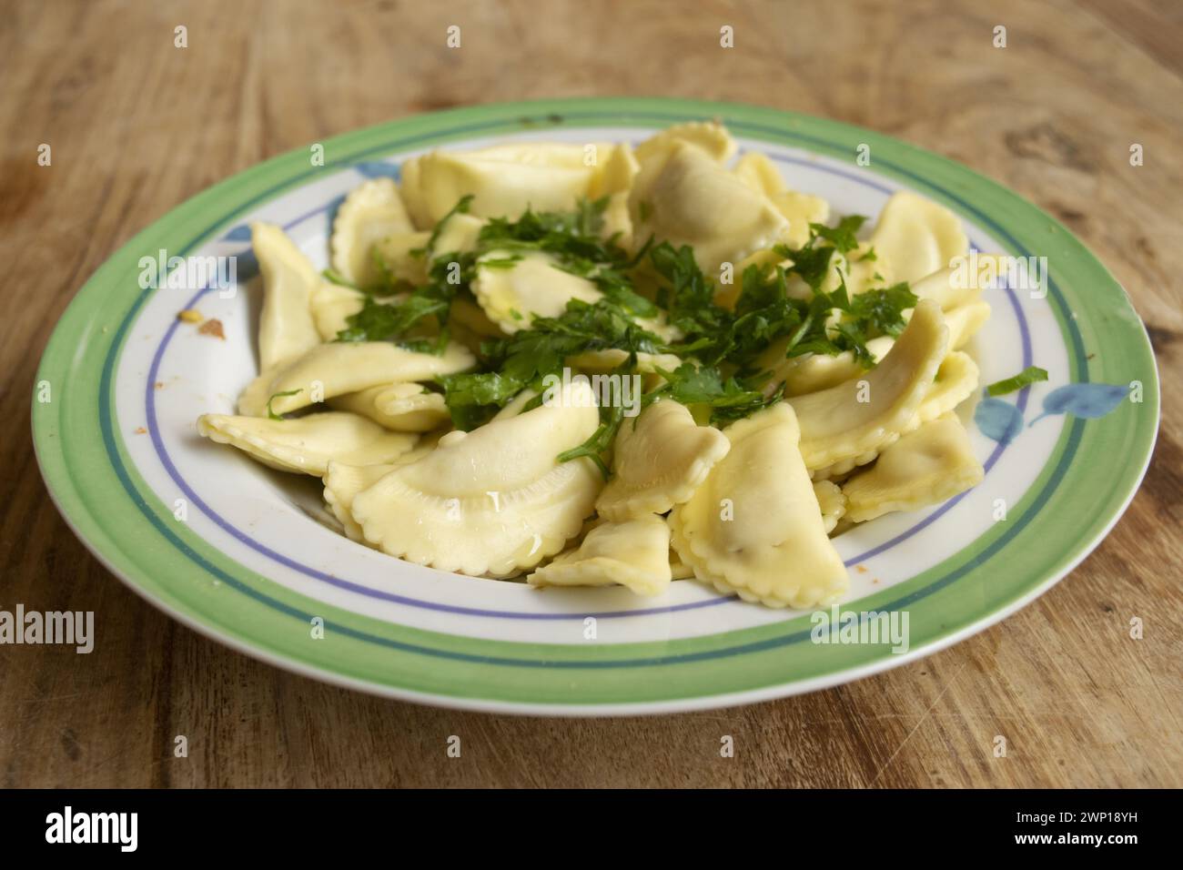 Ravioli di carne conditi con olio ed erbe aromatiche Foto Stock